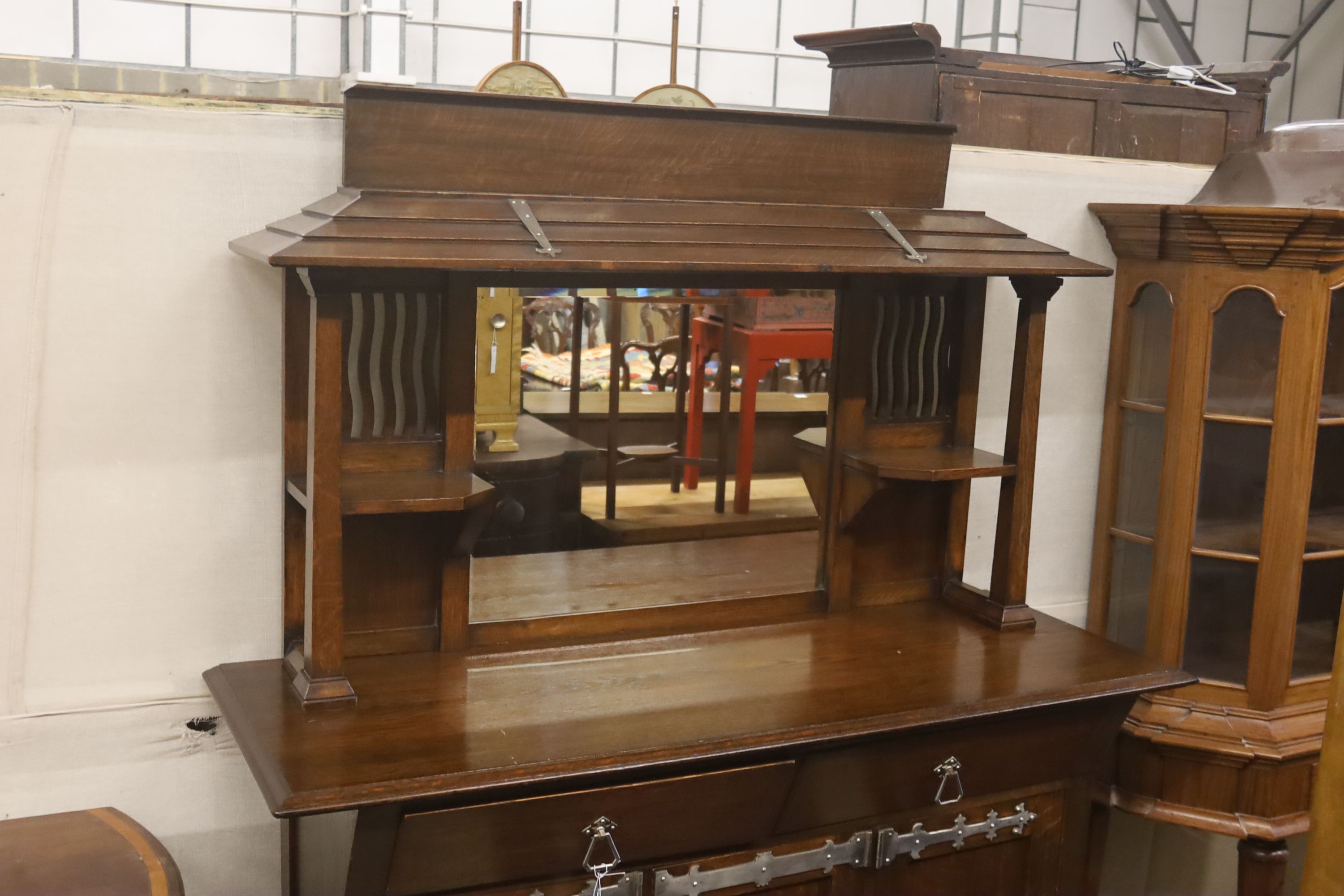 An early 20th century Arts & Crafts oak and polished steel mirrored sideboard, in the manner of Liberty & Co., length 152cm, depth 56cm, height 184cm